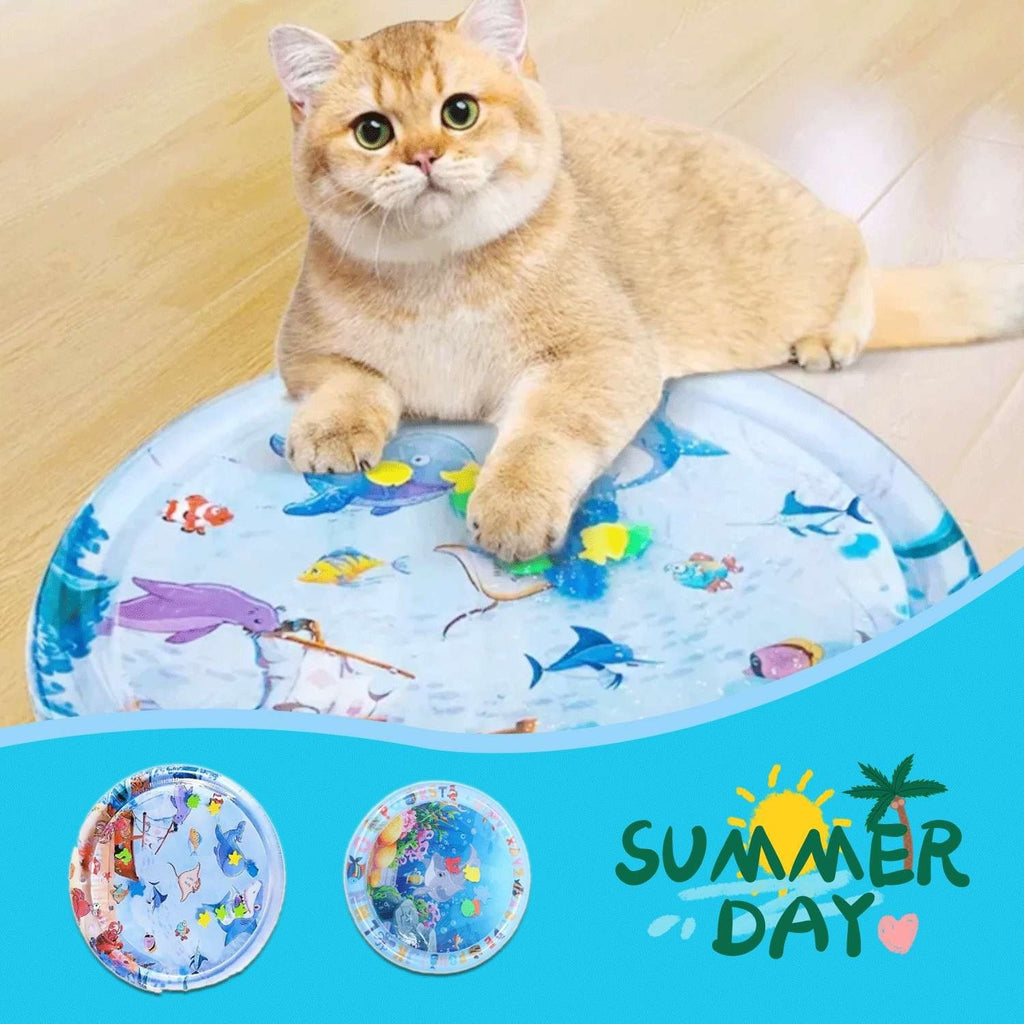 The Tailored Tail cat resting on a durable PVC inflatable cooling water mat with a colorful underwater fish design.